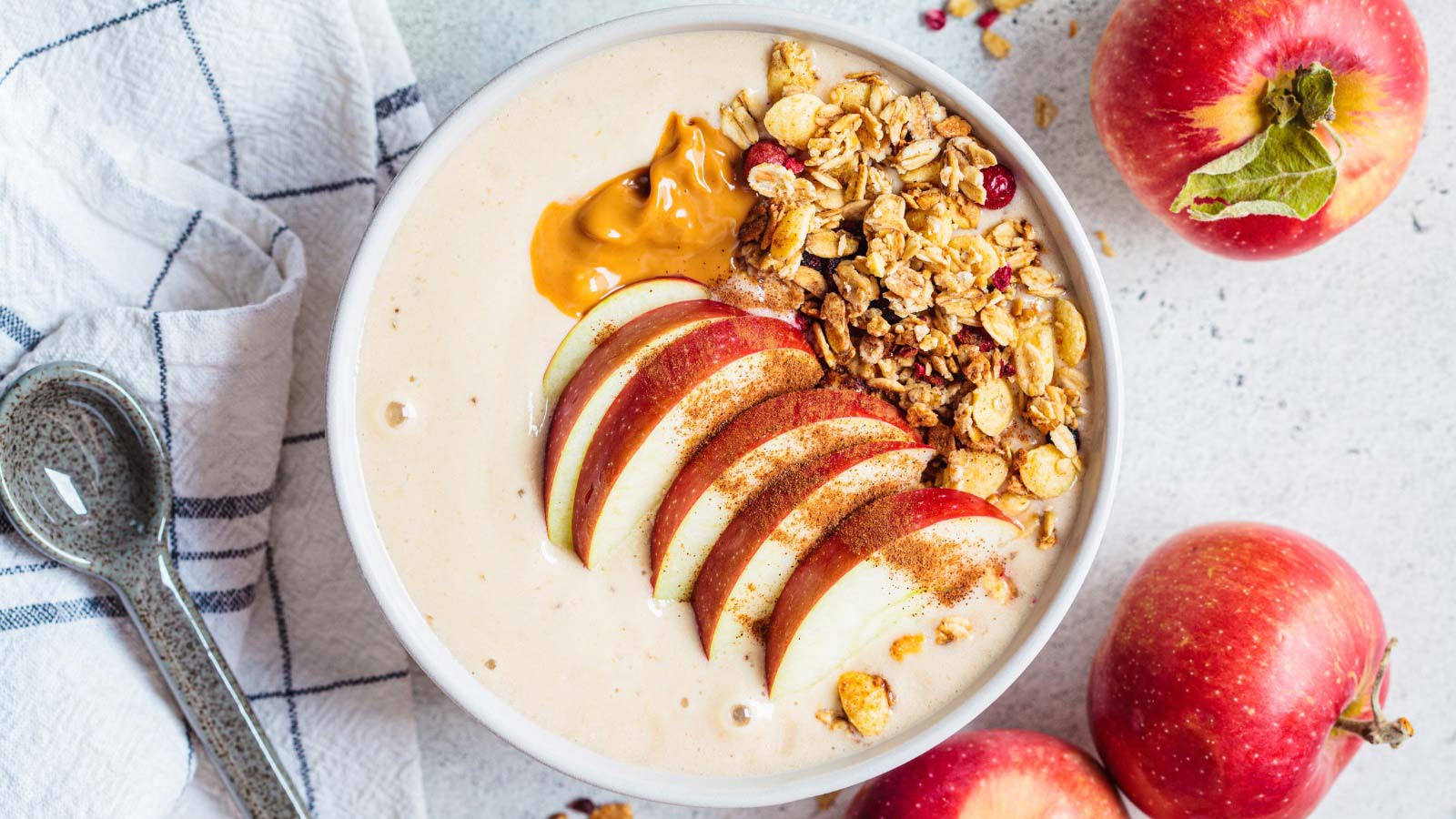 Apple pie smoothie bowl with granola and peanut butter, top view, closeup. Autumn recipe.