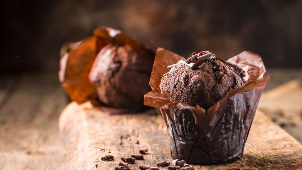 Homemade delicious chocolate muffin on wooden background close-up