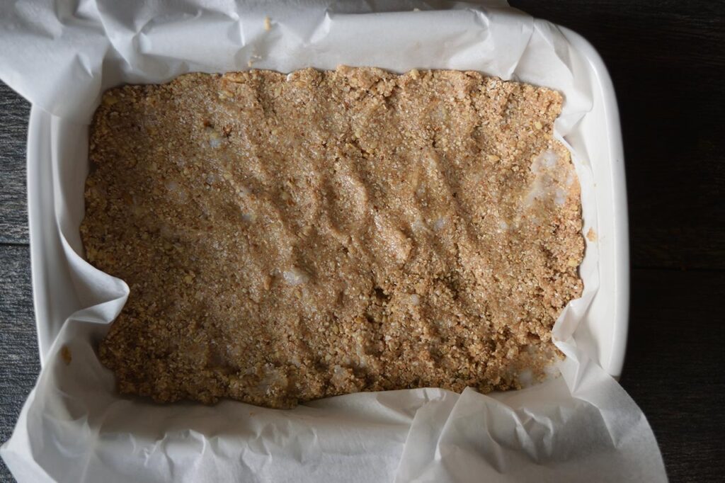 Crust pressed into a parchment-lined baking pan.
