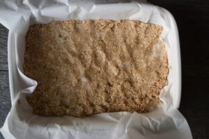Crust pressed into a parchment-lined baking pan.