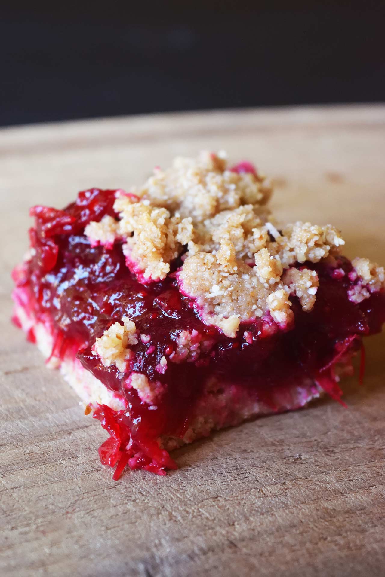 A single cranberry bar sitting on a wood surface.