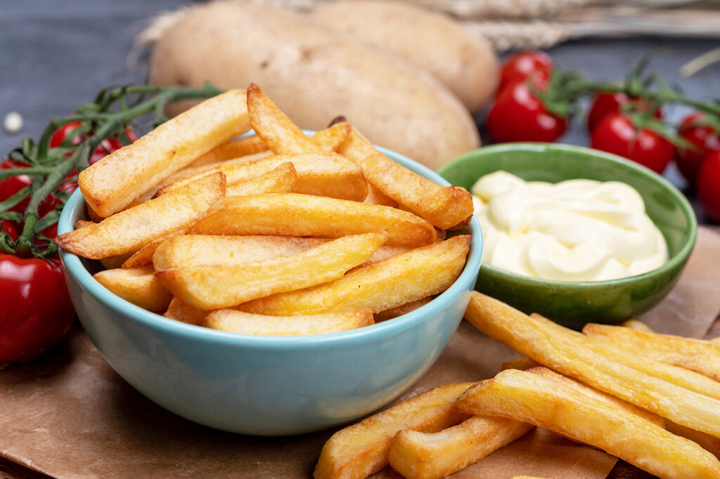Bowl with fresh cooked Belgian fries with mayonnaise sauce close up
