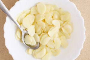 Sliced raw garlic in a white bowl