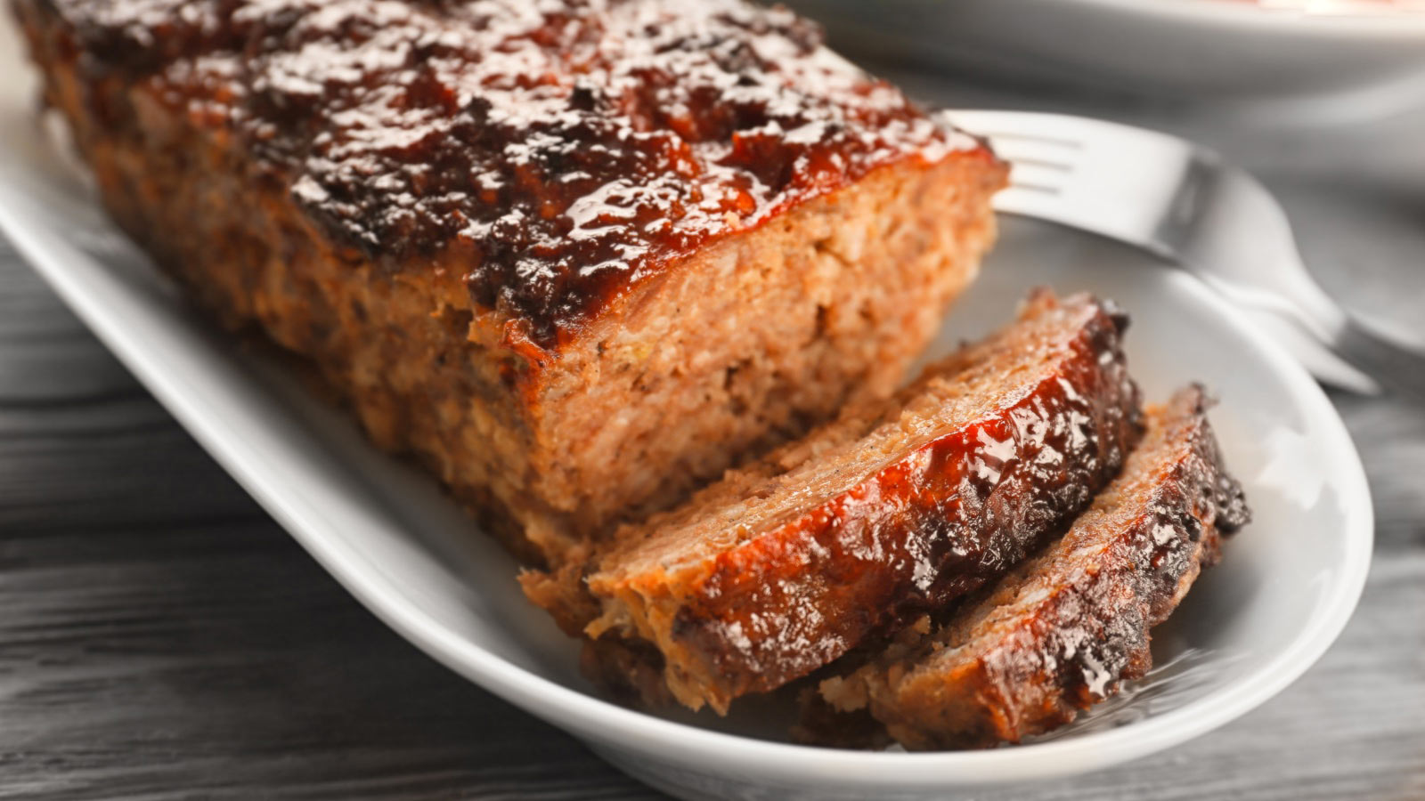 Plate with tasty baked turkey meatloaf on table, closeup.