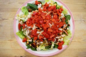 Chopped onions and tomatoes layered over chicken and lettuce.