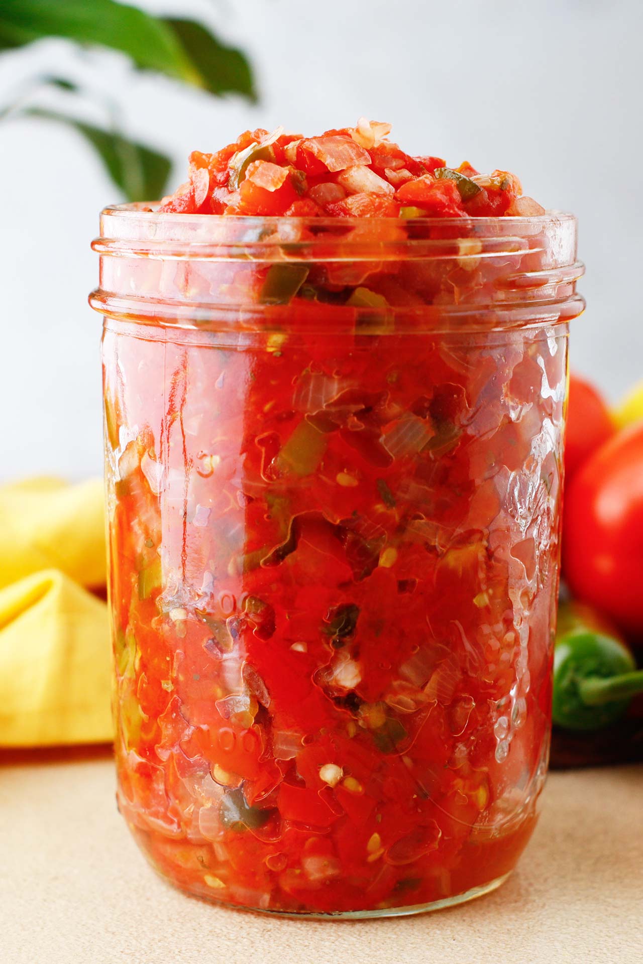 Side view of an open canning jar full of homemade Rotel.
