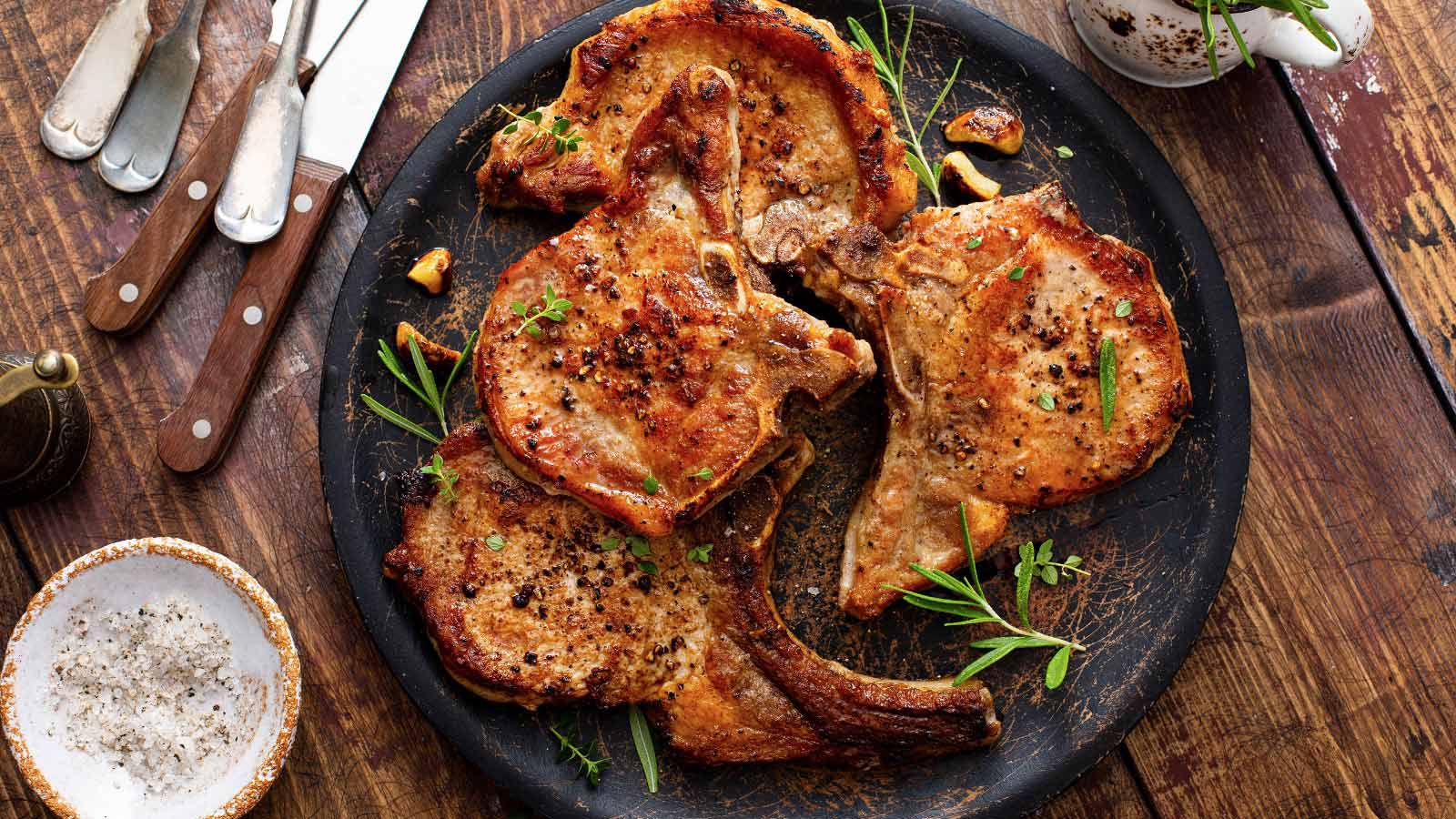 Grilled or pan fried pork chops on the bone with garlic and rosemary
