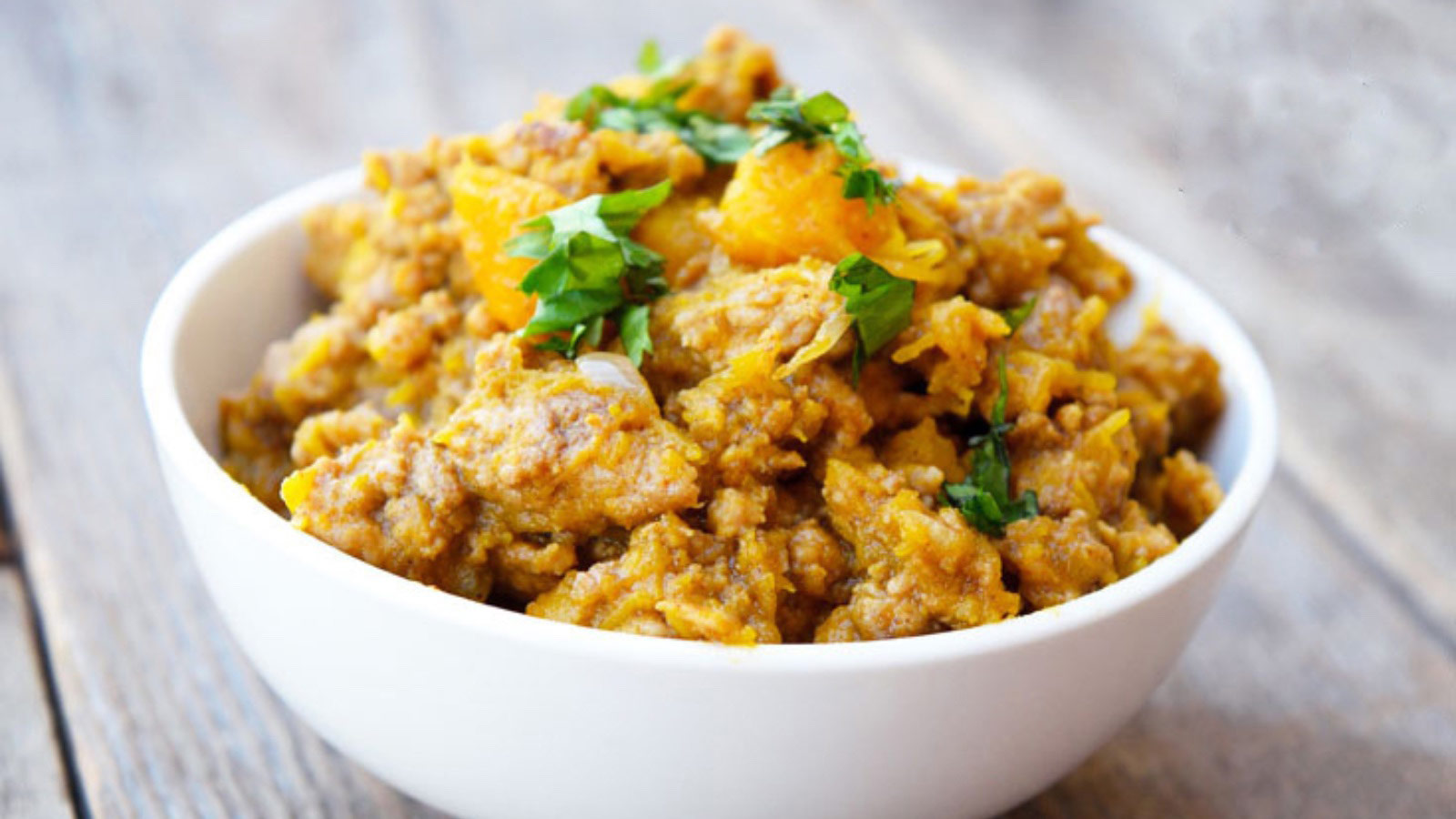 A white bowl filled with pumpkin turkey skillet.
