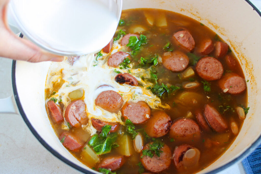 Adding cream to the bowl of soup.