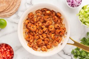 Seasoned, cooked shrimp in a skillet.