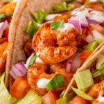Closeup of a shrimp taco on a platter.