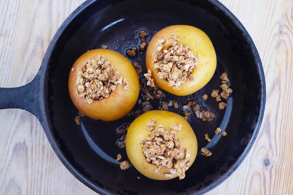 Overhead view of three Baked Breakfast Apples in a skillet.