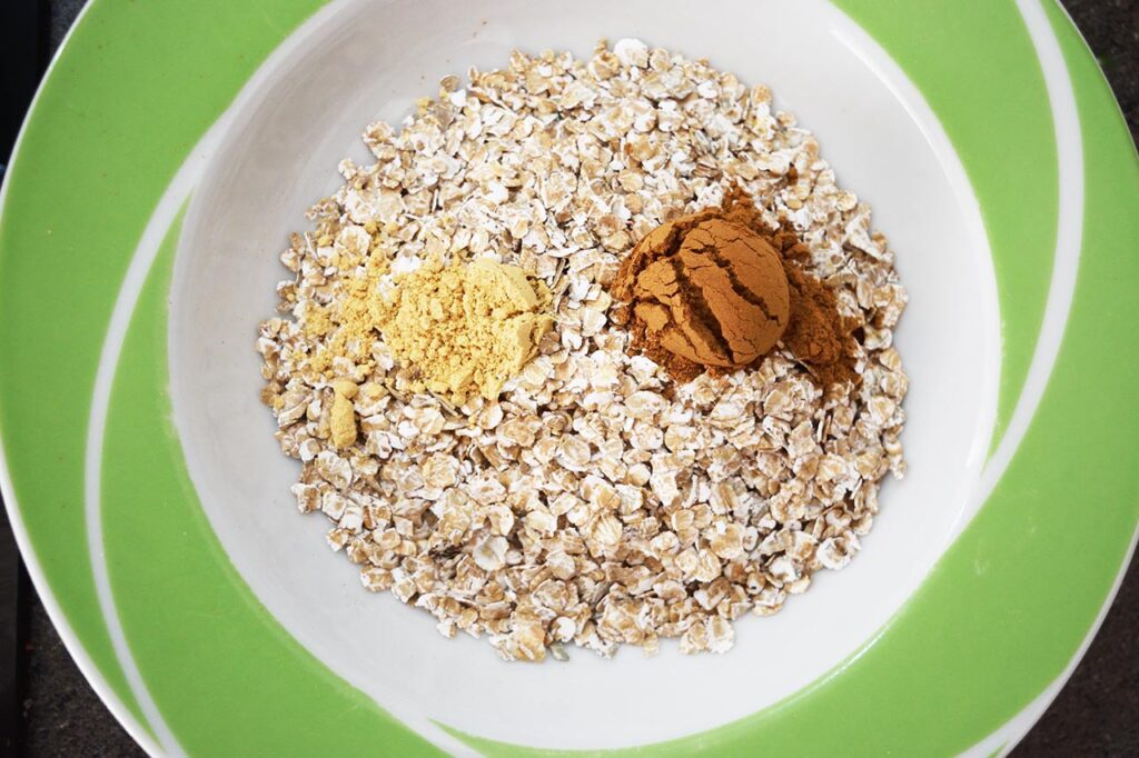 Spices added to oats in a bowl.