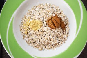 Spices added to oats in a bowl.