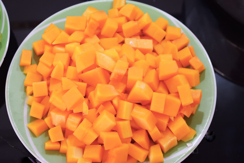 Cut, raw butter squash in a bowl.