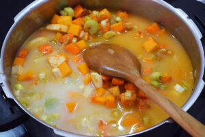 Broth added to vegetable in a pot.