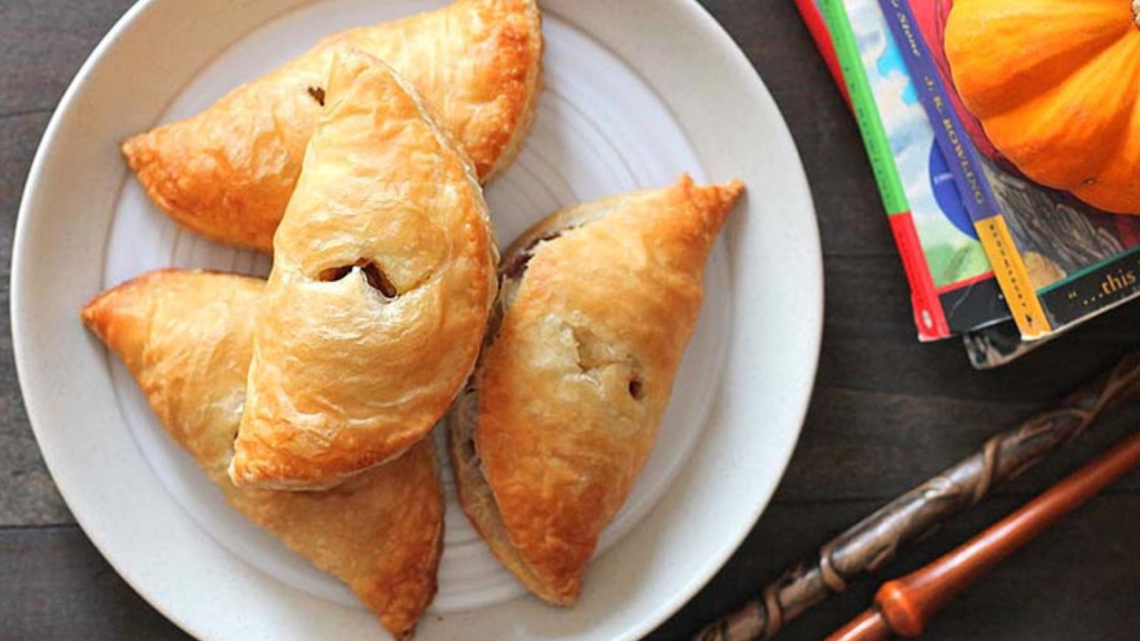Four pumpkin pasties on a white plate.