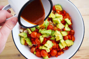Pouring dressing over a just-made Mexican Dense Bean Salad.