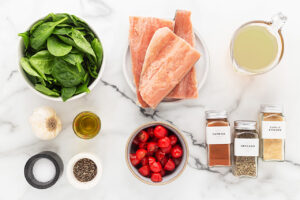 Mediterranean Salmon Soup recipe ingredients on a white marble surface.