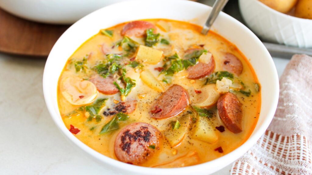 A white bowl filled with Sausage Kale And Potato Soup.