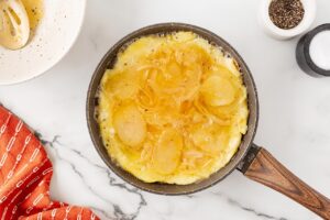 Nearly cooked Tortilla Española in a skillet.