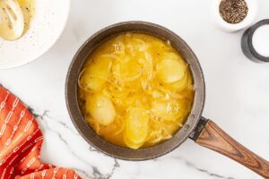 Raw Tortilla Española cooking in a skillet.