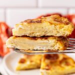 A spatula holds two, stacked slices of Tortilla Española.