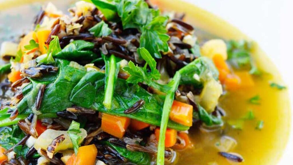 A white bowl filled with wild rice vegetable soup.
