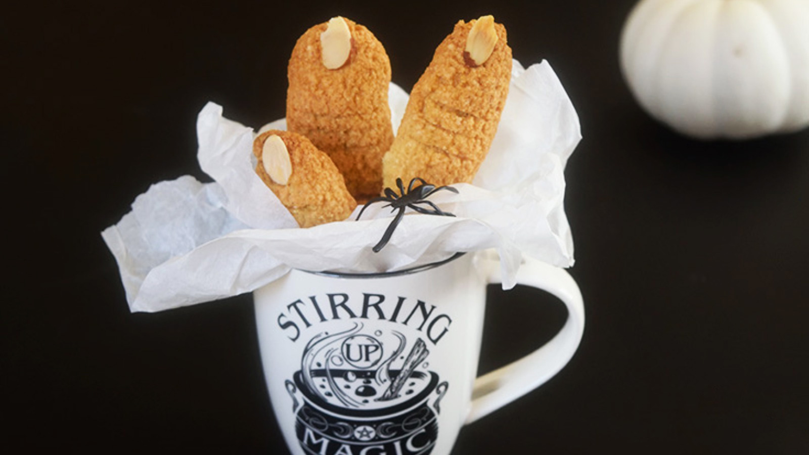 Witch Finger Cookies in parchment paper set inside a white and black Halloween mug.