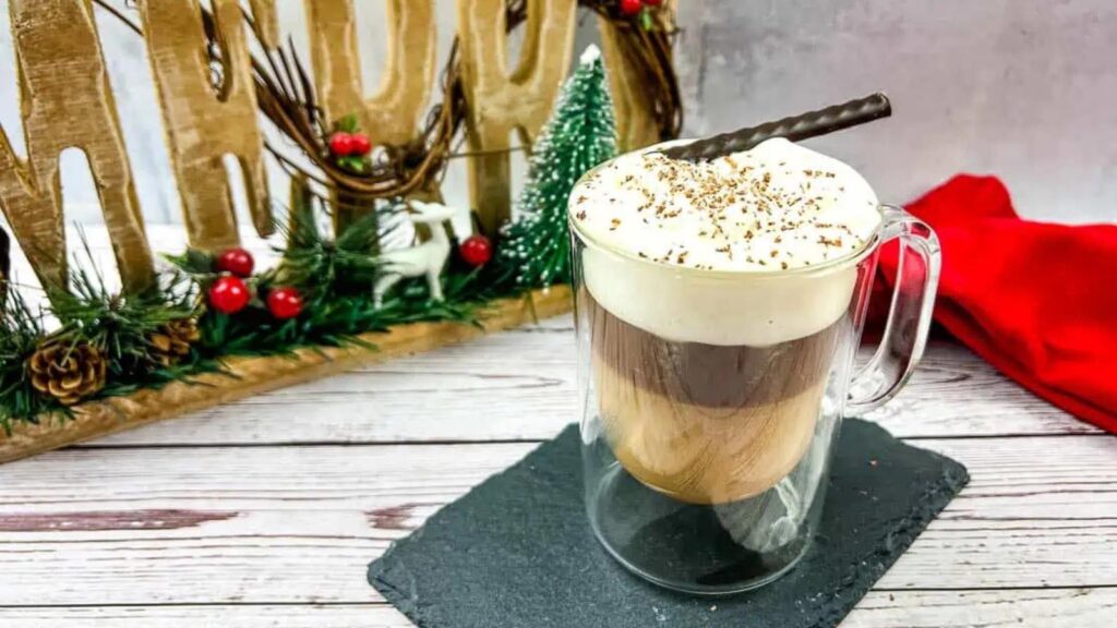A Canadia coffee topped with whipped cream in a glass mug.