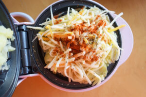 Spices sprinkled over cheese on a smashed potato.