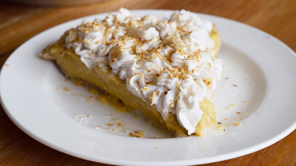 A single slice of the finished coconut cream pie on a white plate.