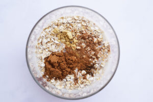 Milk added to a glass jar with oats and spices.