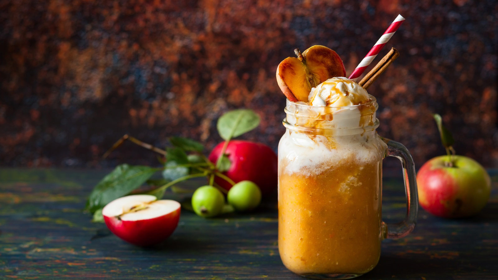 Apple cider float with caramel sauce and stick of cinnamon.