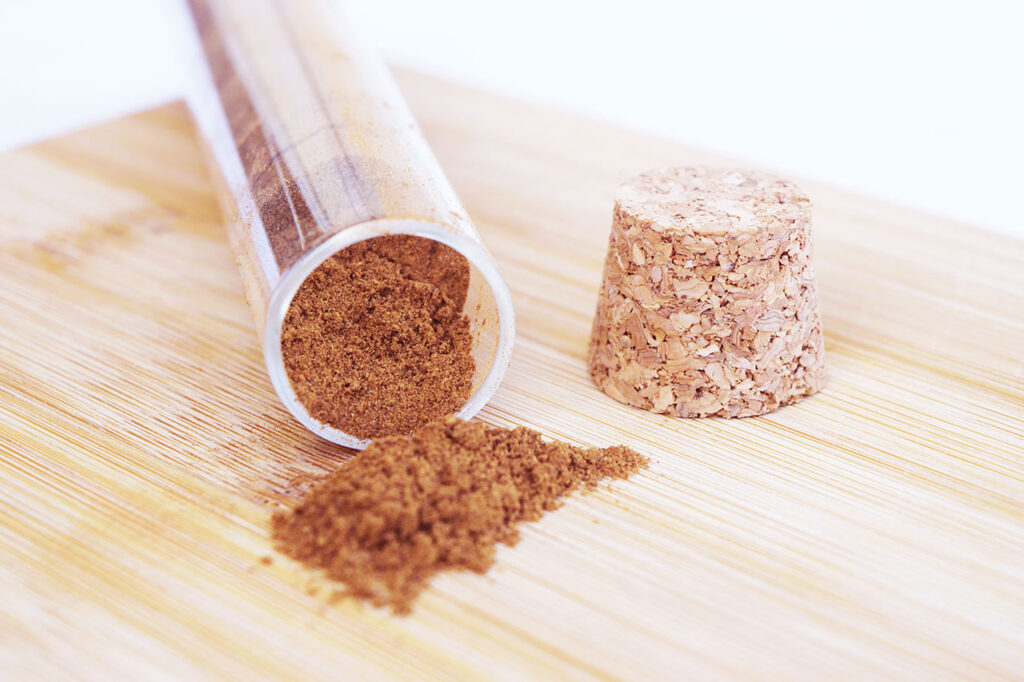 A tipped over jar of mulling spices on a wood surface.