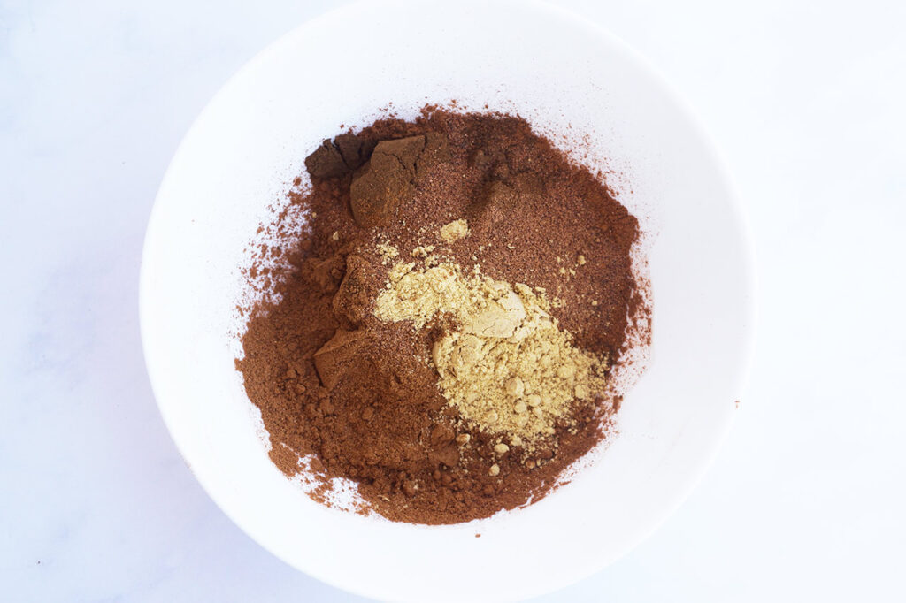 Mulling spices added to a white mixing bowl. Overhead view.