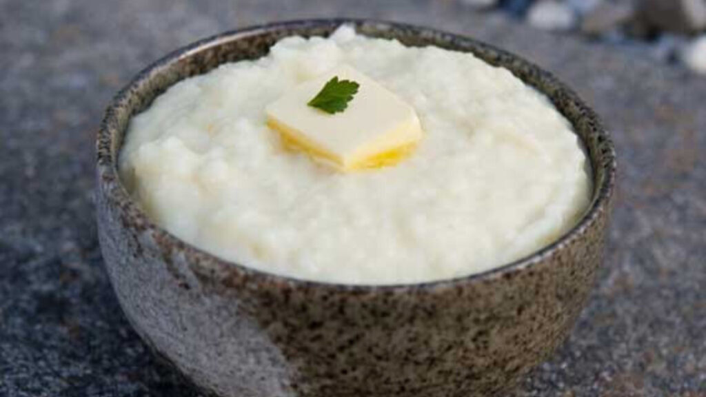 A bowl filled with holiday mashed potatoes and topped with a pat of butter.