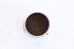 Bottom section of a Moka pot filled with water.