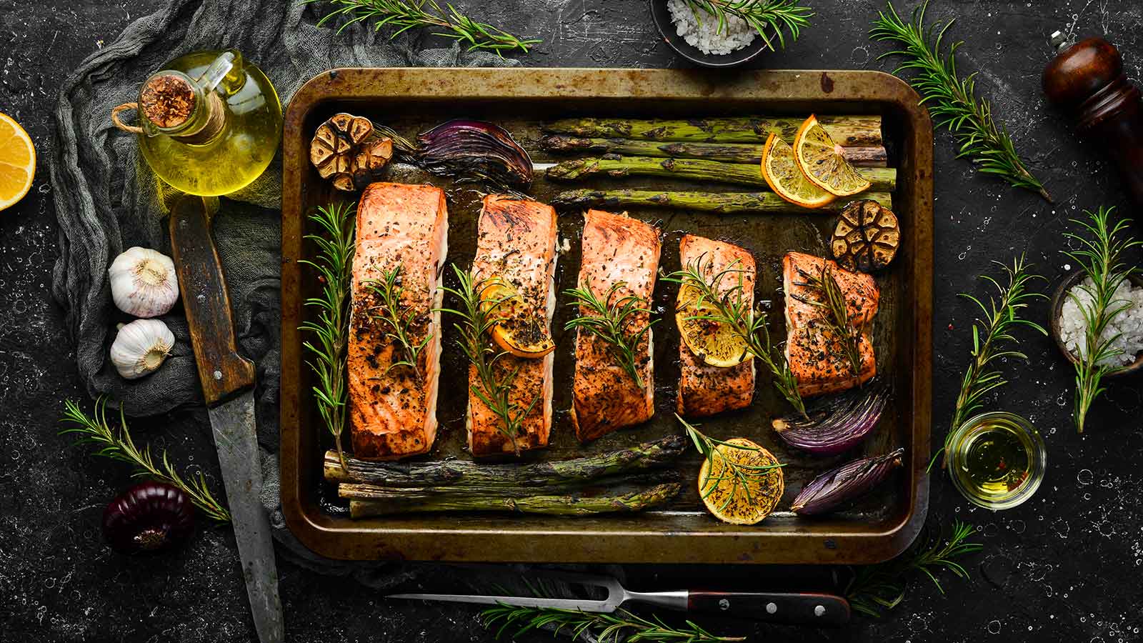 Salmon baked in a metal tray with vegetables and rosemary. Recipe. Seafood. Free space for text.