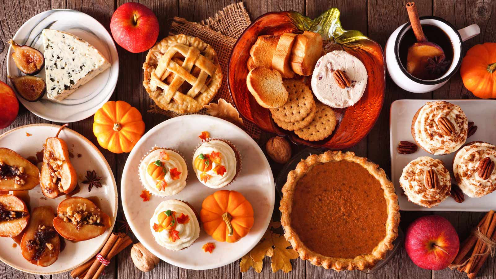 Autumn food concept. Selection of pies, appetizers and desserts. Above view table scene over a rustic wood background.
