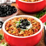 Two red crocks filled with Slow Cooker Tortilla Chicken Stew.