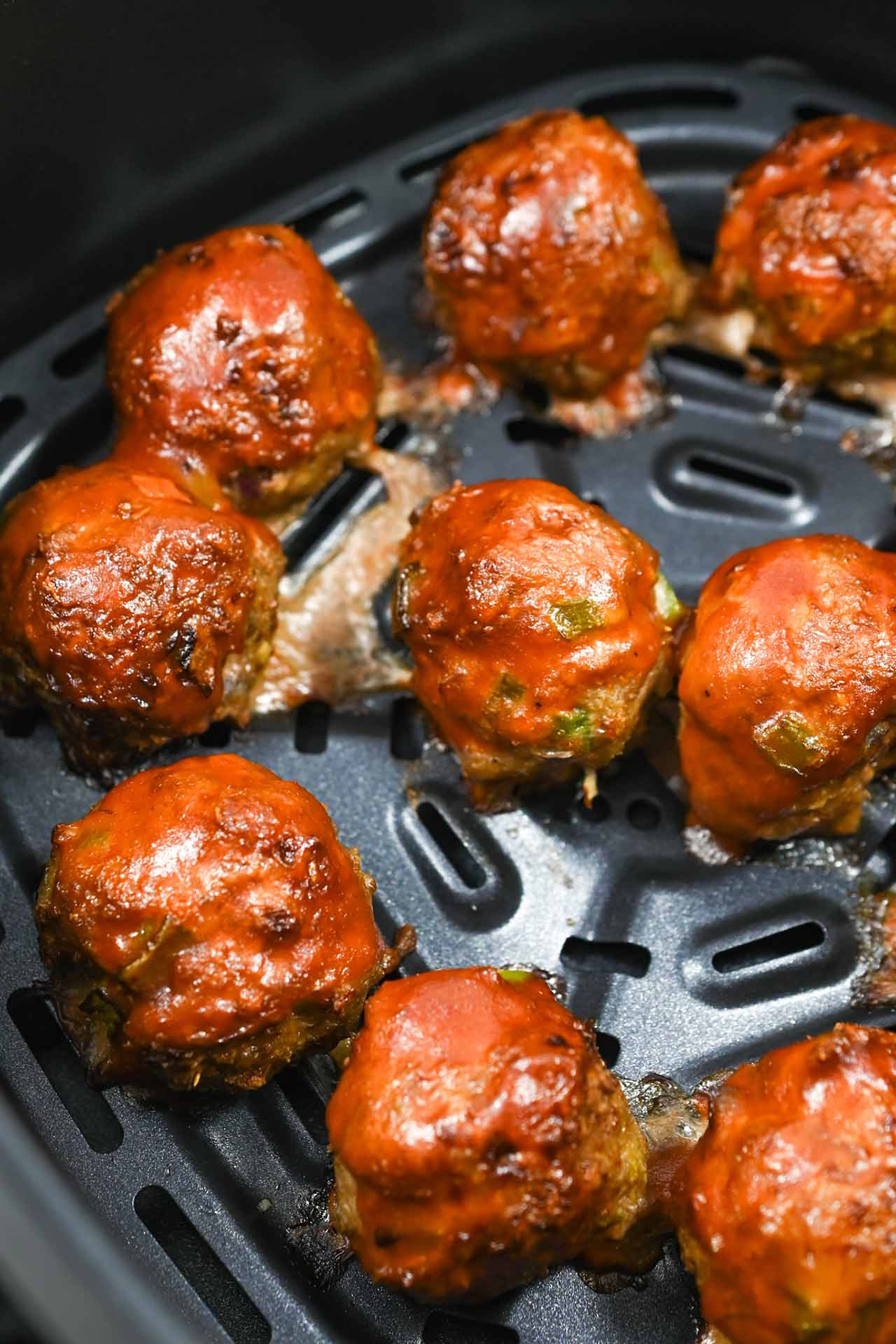 Closeup of Air Fryer Meatballs sitting in an air fryer basket.