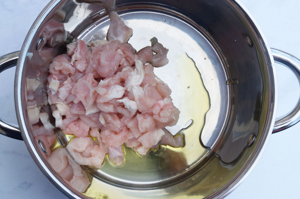 Cut chicken and oil in a soup pot.