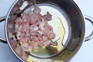 Cut chicken and oil in a soup pot.