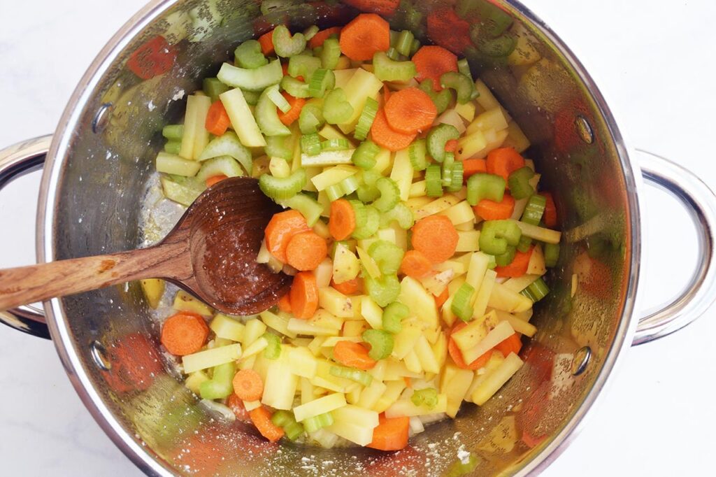 Partially cooked veggies in a soup pot.