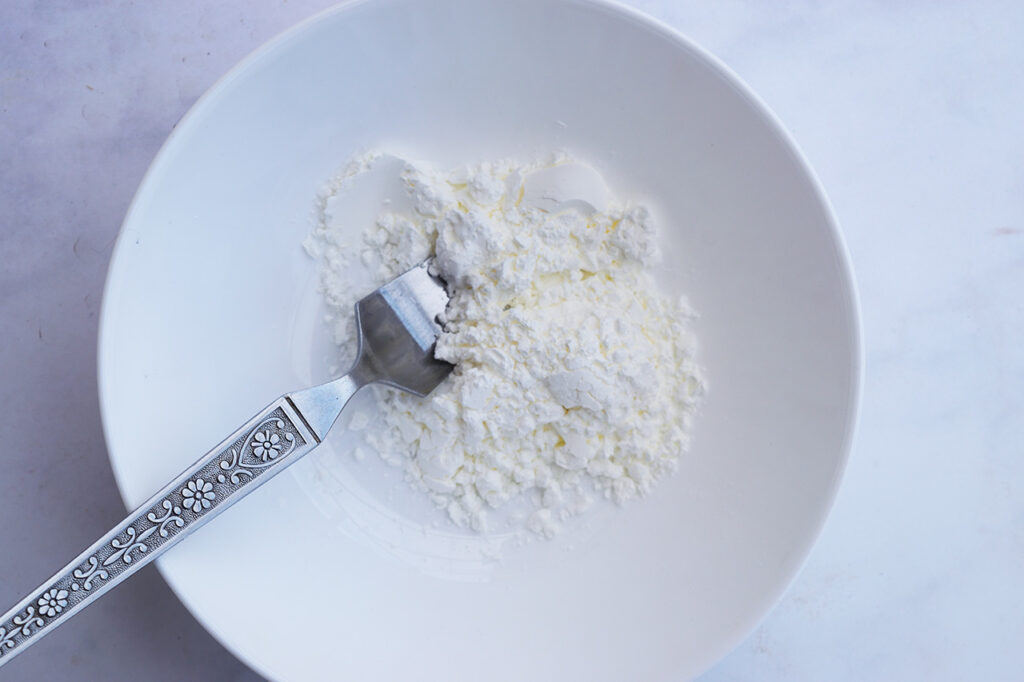 Cornstarch in a bowl with a fork.