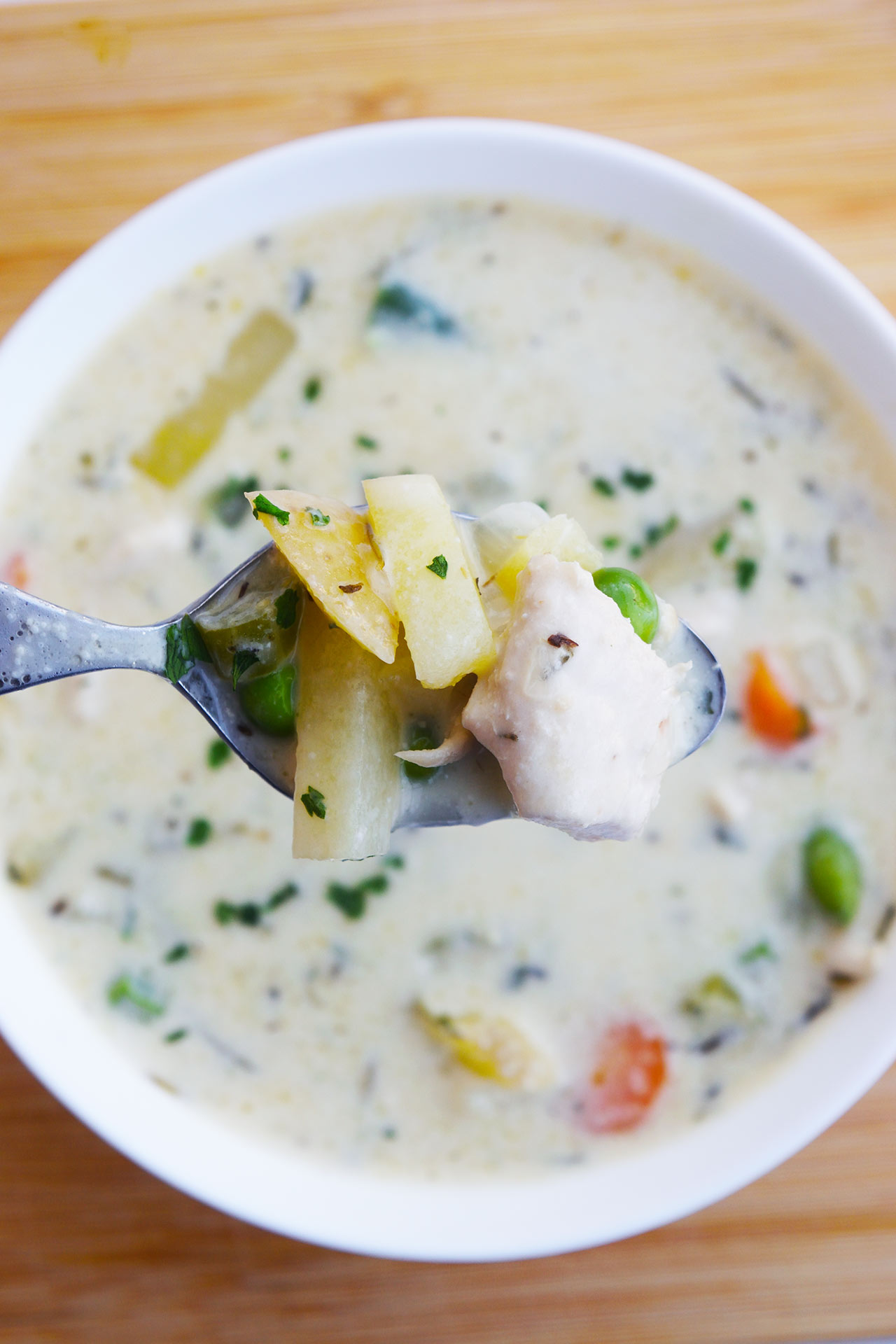 Overhead view of a spoon holding Chicken Pot Pie Soup.