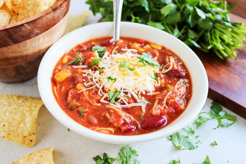Front view of a white bowl full of Chicken Taco Chili.