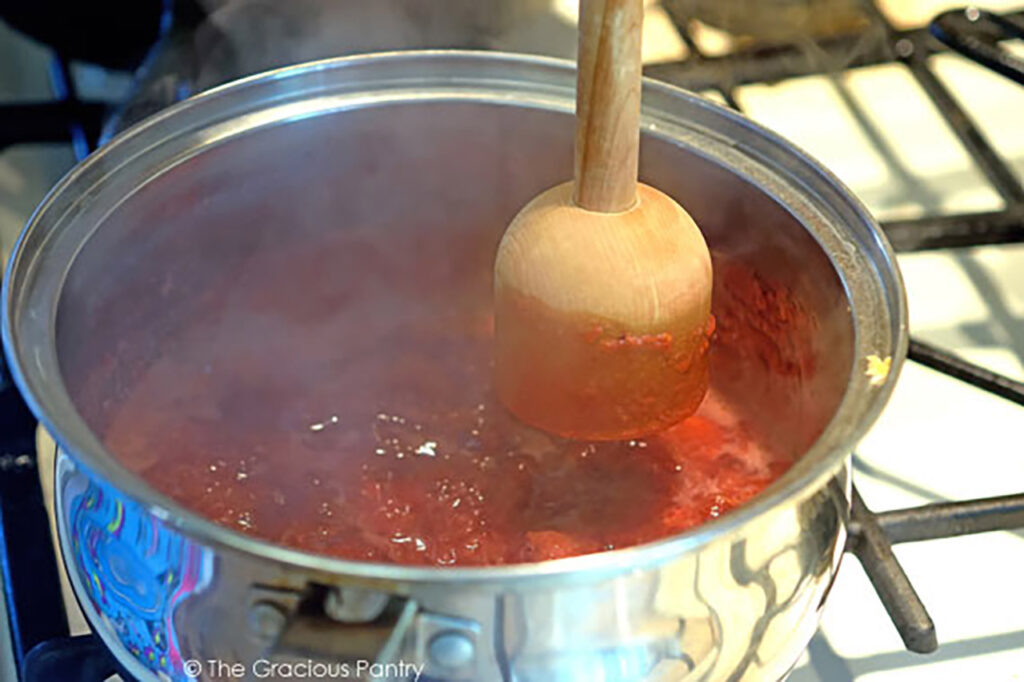 Mashing berries in a hot pot.