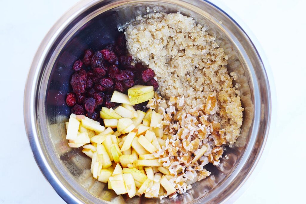 Cranberry Apple Quinoa Salad recipe ingredients in a mixing bowl, unmixed.